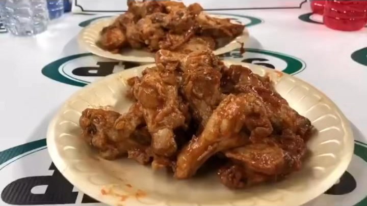Close-up of sauced chicken wings on plates at the Wing Bowl stage